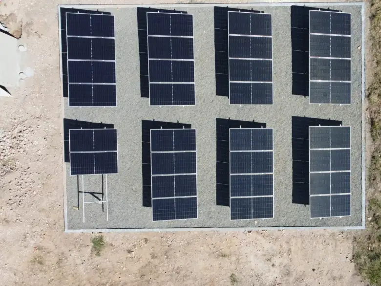Vista aérea de usina solar em solo, com painéis em fileiras sobre área cercada, em Filadélfia/TO