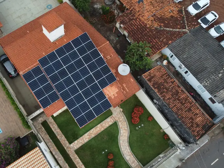 Vista aérea de residência em Araguaína/TO com jardim, piscina e painéis solares no telhado