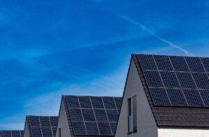 Painéis solares instalados nos telhados de casas residenciais sob céu azul.